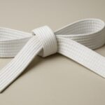 A neatly tied white karate belt displayed on a neutral background.